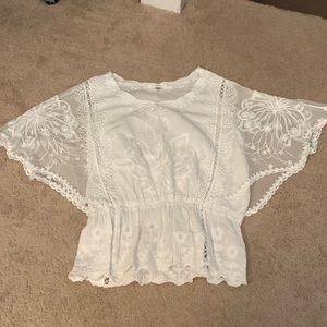 Sheer flowy short sleeve peplum top with floral detail.